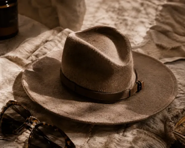 A felt hat resting on linen.